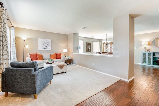 living room featuring an inviting chandelier and wood-type flooring