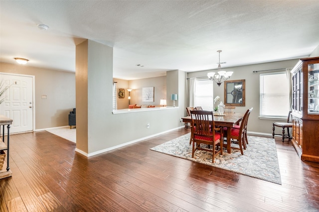 dining room with an inviting chandelier and dark wood-type flooring