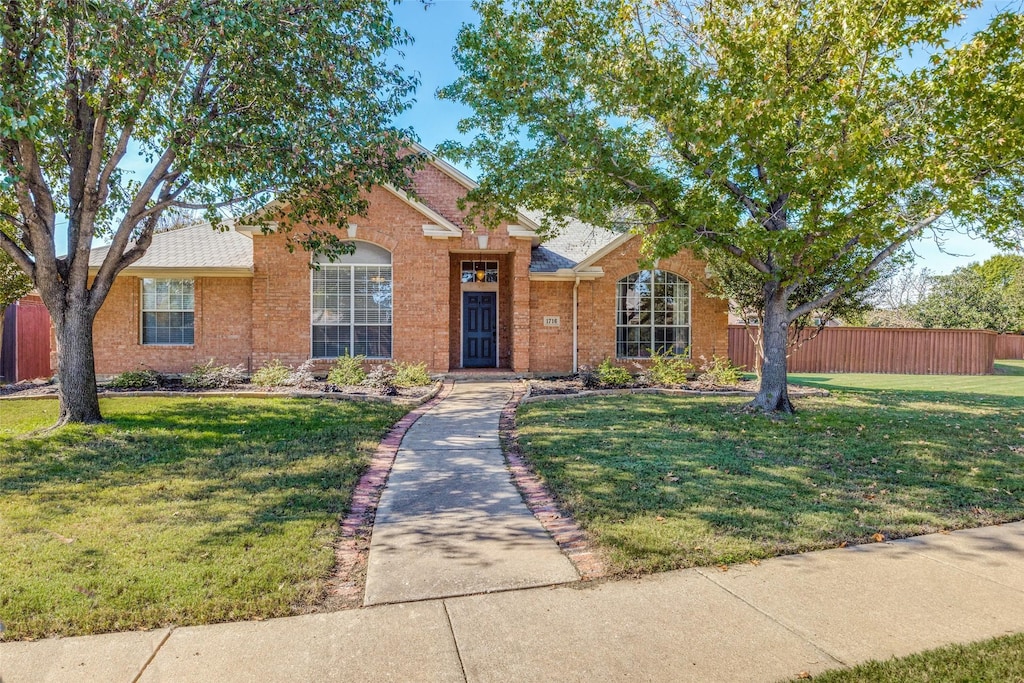 ranch-style home featuring a front yard