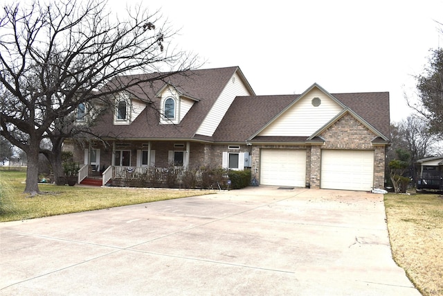 view of front of property featuring a garage, covered porch, and a front yard