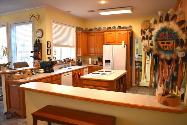 kitchen with ornamental molding, white appliances, visible vents, and a kitchen island