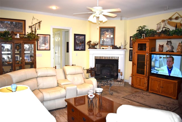 living area with ceiling fan, ornamental molding, and wood finished floors