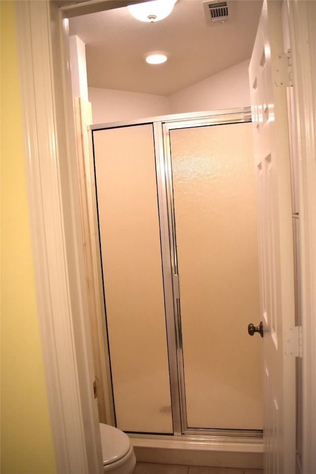 full bath featuring toilet, a stall shower, and visible vents