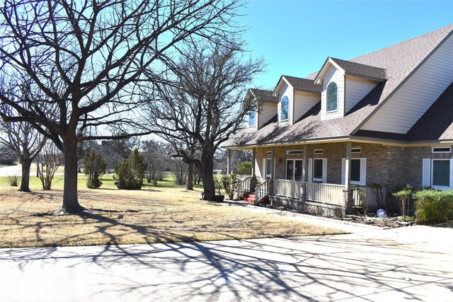 view of front of property with a garage, a front yard, and a porch