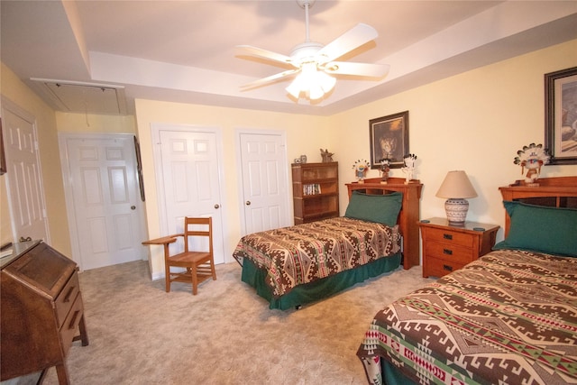 bedroom with attic access, a ceiling fan, and light colored carpet