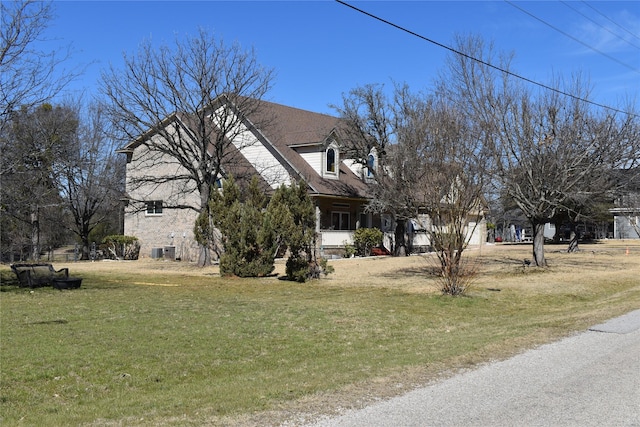 view of side of home featuring a lawn, an attached garage, and cooling unit