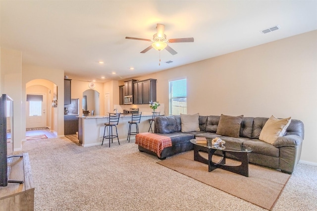 living room with light colored carpet and ceiling fan