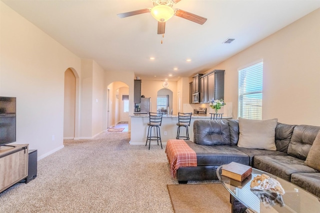 living room with ceiling fan and light colored carpet