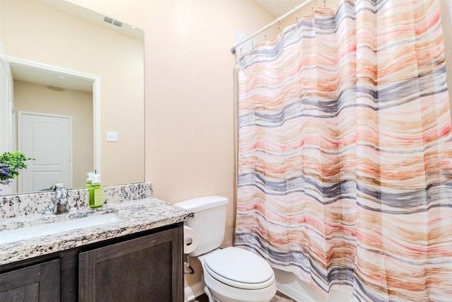 full bathroom with vanity, shower / tub combo, and toilet