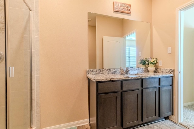 bathroom with walk in shower and vanity