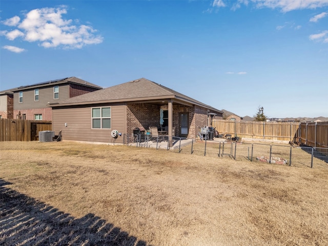 rear view of house with central AC, a yard, and a patio