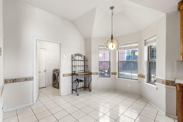 unfurnished dining area with washer / clothes dryer, lofted ceiling, and light tile patterned floors