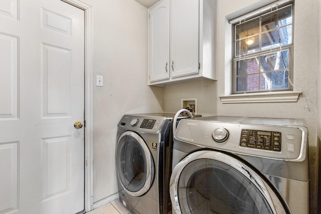 laundry area with washer and dryer, cabinets, and light tile patterned flooring