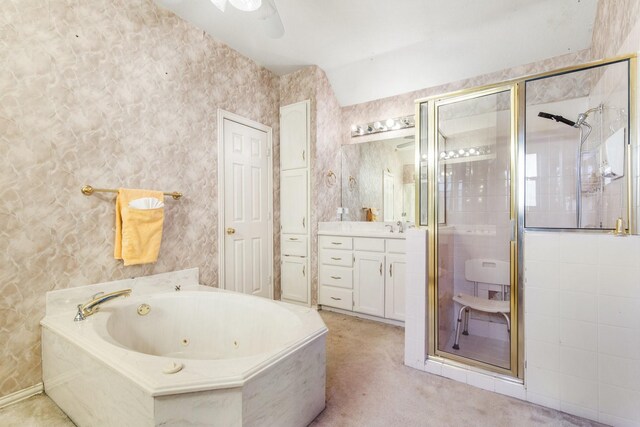 bathroom with ceiling fan, vanity, vaulted ceiling, and a tub