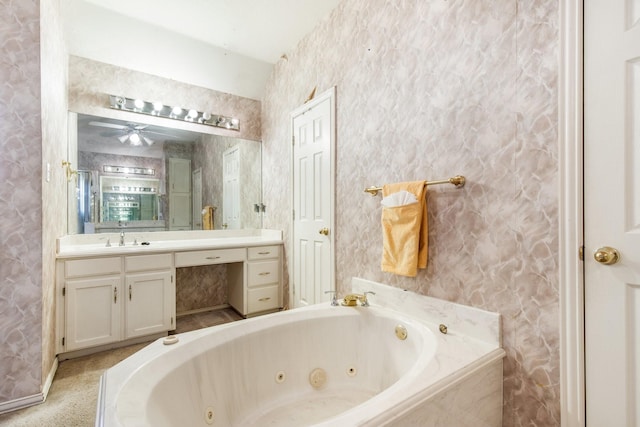 bathroom with ceiling fan, a tub to relax in, and vanity