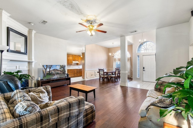 living room featuring ceiling fan with notable chandelier and light hardwood / wood-style floors