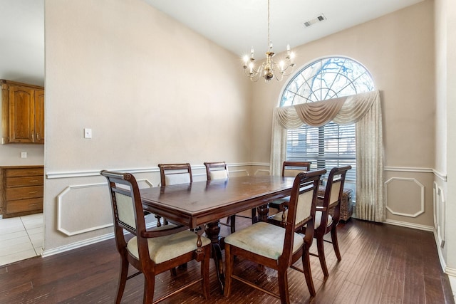 dining space with hardwood / wood-style flooring and a chandelier