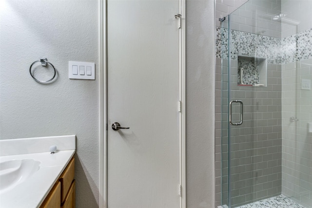 bathroom featuring vanity and a shower with shower door