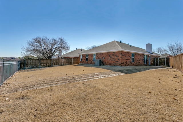 back of house featuring a lawn and central air condition unit