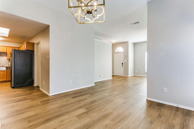 interior space with light hardwood / wood-style floors and a skylight