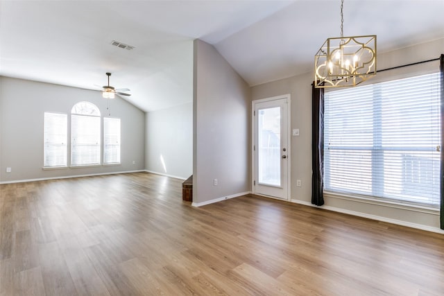 interior space featuring ceiling fan with notable chandelier, vaulted ceiling, and hardwood / wood-style floors