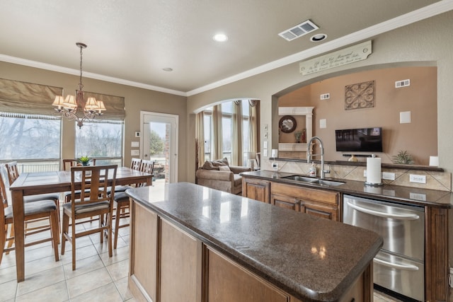 kitchen with sink, a chandelier, hanging light fixtures, light tile patterned floors, and crown molding