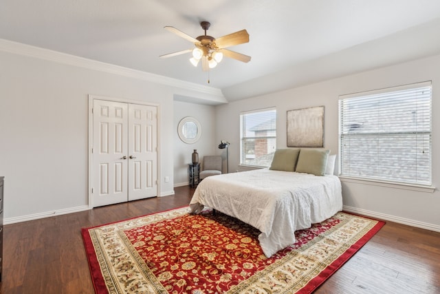 bedroom featuring dark wood-type flooring, ceiling fan, crown molding, and a closet