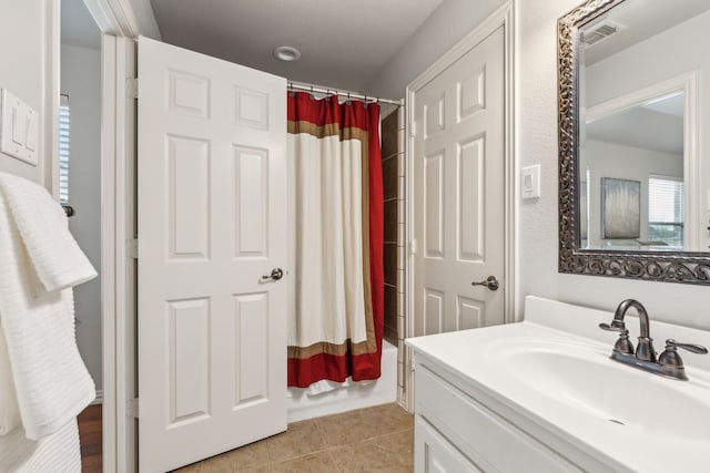 bathroom featuring tile patterned floors, shower / bathtub combination with curtain, and vanity