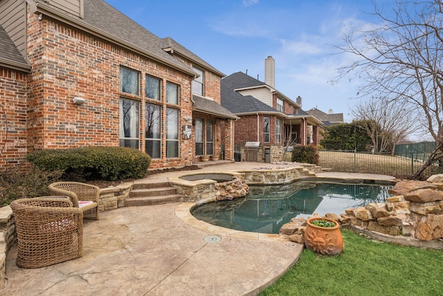 view of swimming pool featuring a grill, a patio area, and an in ground hot tub