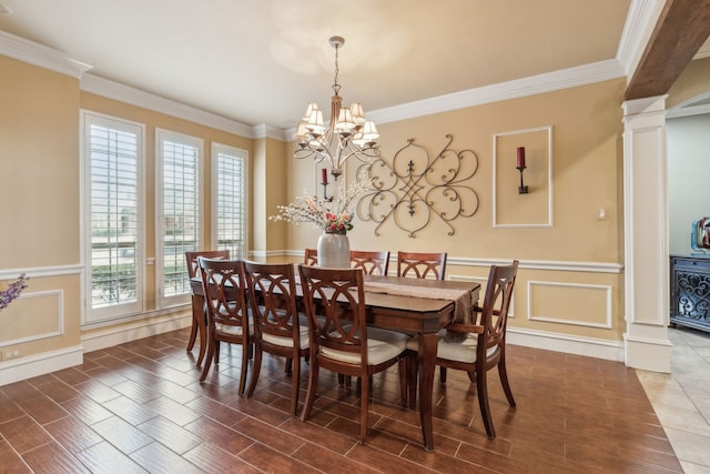 dining space featuring an inviting chandelier, crown molding, and ornate columns