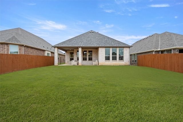 rear view of house featuring a lawn