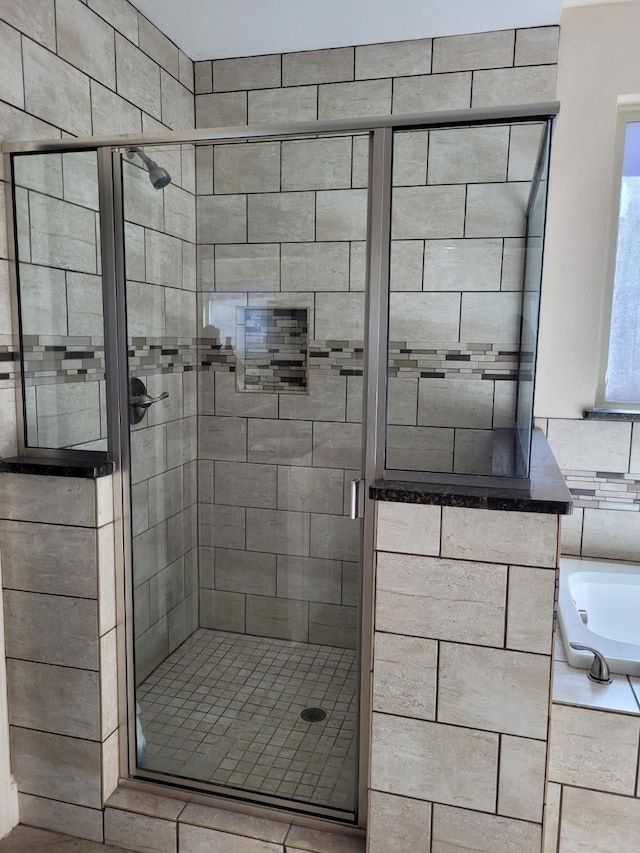 bathroom featuring separate shower and tub