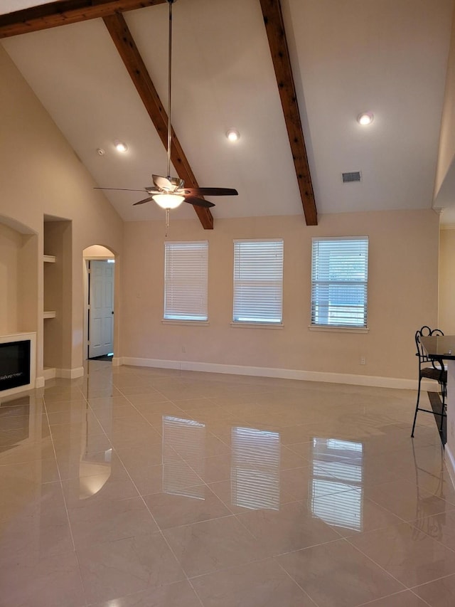 unfurnished living room with ceiling fan, high vaulted ceiling, light tile patterned flooring, built in shelves, and beamed ceiling