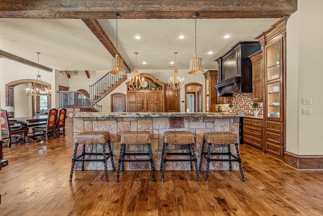 kitchen featuring pendant lighting, a spacious island, a breakfast bar, and a chandelier