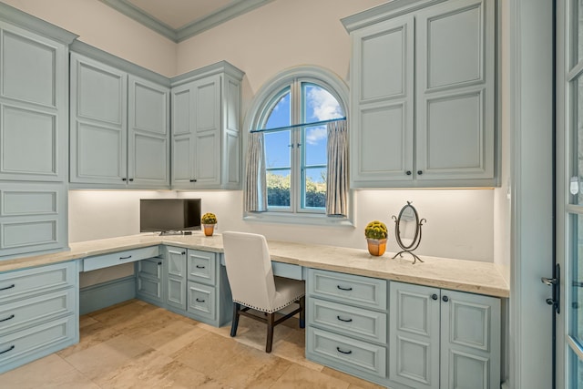 office space featuring crown molding and built in desk