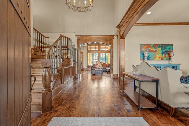 entryway with a high ceiling, wood-type flooring, and a notable chandelier