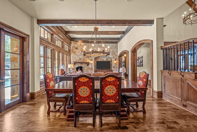 dining area featuring beam ceiling, hardwood / wood-style floors, and a chandelier