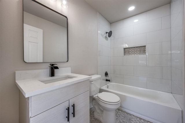 full bathroom featuring tiled shower / bath, vanity, and toilet