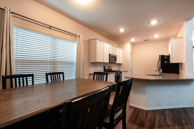 dining space with dark hardwood / wood-style floors and sink