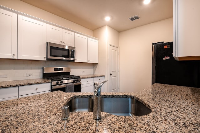 kitchen featuring sink, stainless steel appliances, white cabinets, and stone counters