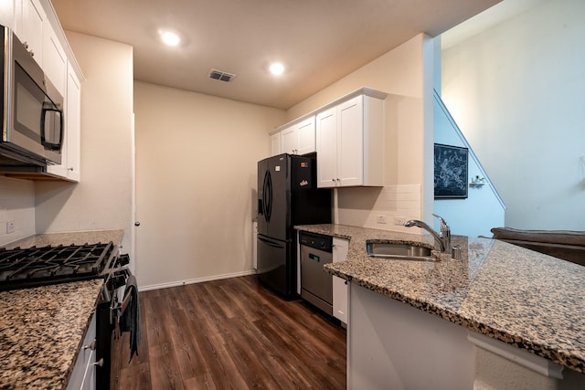 kitchen featuring stone counters, white cabinetry, sink, black appliances, and dark wood-type flooring