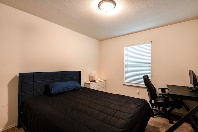 bedroom featuring carpet flooring and a textured ceiling