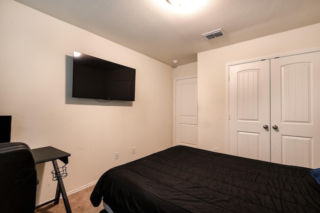 carpeted bedroom featuring a closet and a textured ceiling