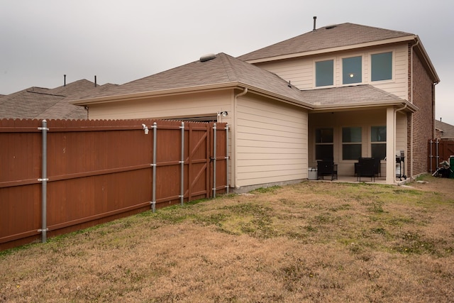 rear view of property with a patio and a lawn