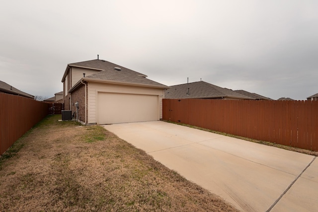 view of home's exterior with cooling unit, a garage, and a lawn