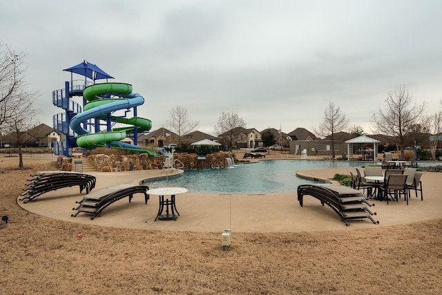 view of swimming pool with a water slide and a playground