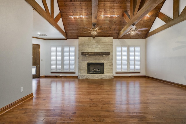 unfurnished living room with ceiling fan, a healthy amount of sunlight, a fireplace, and beam ceiling