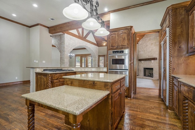 kitchen with decorative light fixtures, stainless steel appliances, dark hardwood / wood-style floors, and a kitchen island