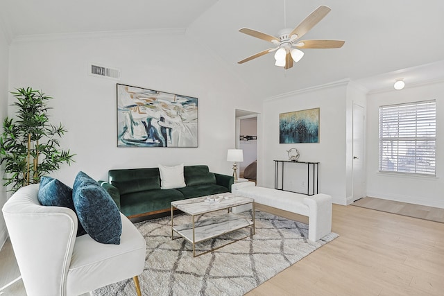 living room with vaulted ceiling, crown molding, and light hardwood / wood-style flooring