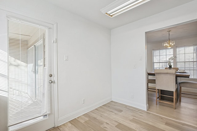 dining area with an inviting chandelier and light hardwood / wood-style flooring